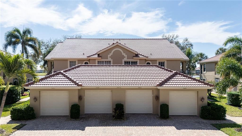 Mediterranean style home with stucco siding, a tile roof, and detached garages