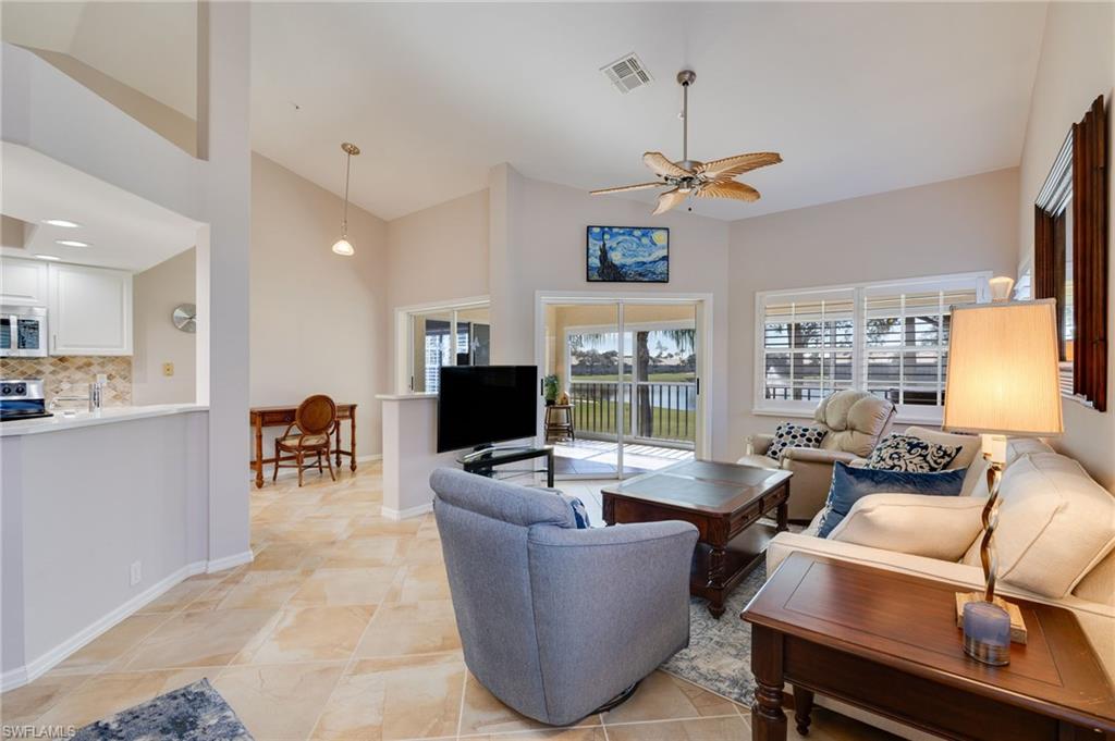 Living room featuring volume ceilings/ open area to kitchen and screened balcony