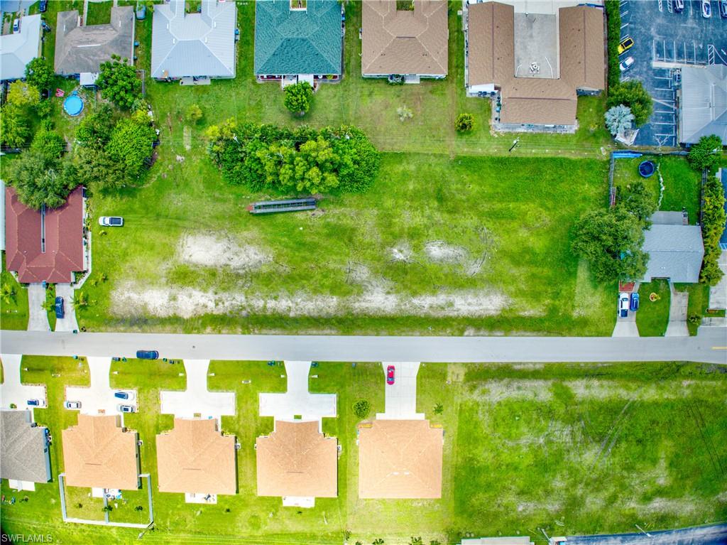 Aerial view of property and surrounding area with nearby suburban area
