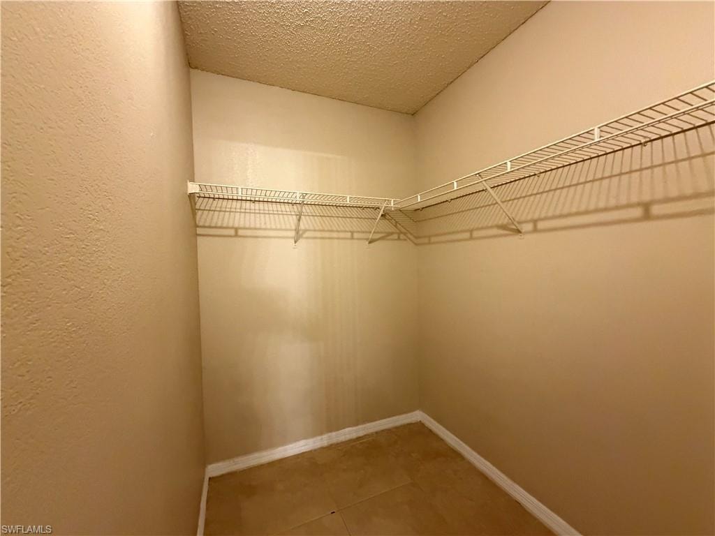 Walk in closet with light tile patterned floors
