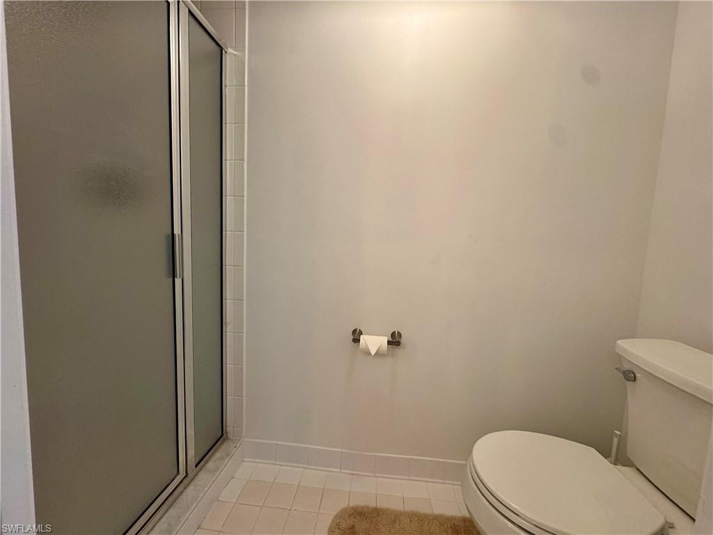 Bathroom with a stall shower and light tile  floors