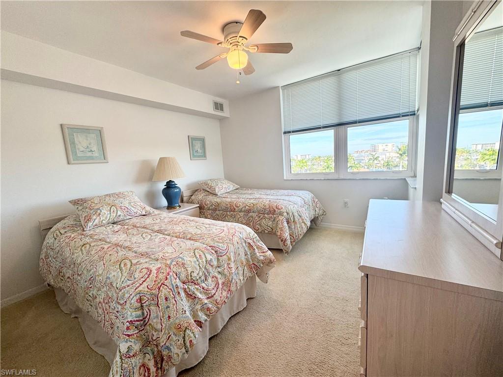 Bedroom with light colored carpet and a ceiling fan