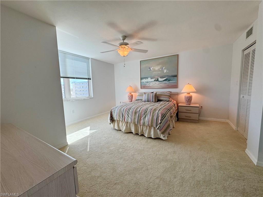 Bedroom with light carpet, a ceiling fan, and a closet