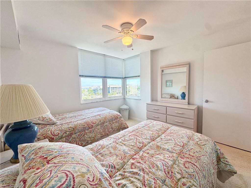 Bedroom with light carpet and a ceiling fan