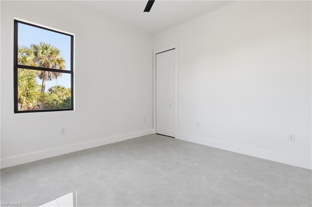 Empty room featuring baseboards and ceiling fan