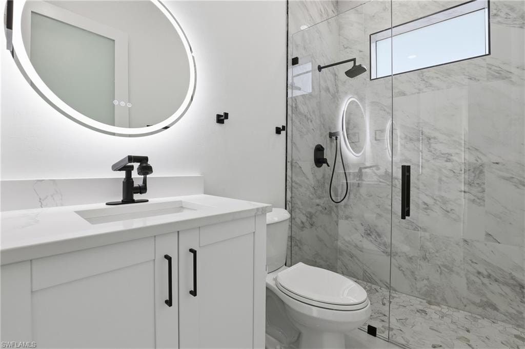 Bathroom with a marble finish shower and vanity