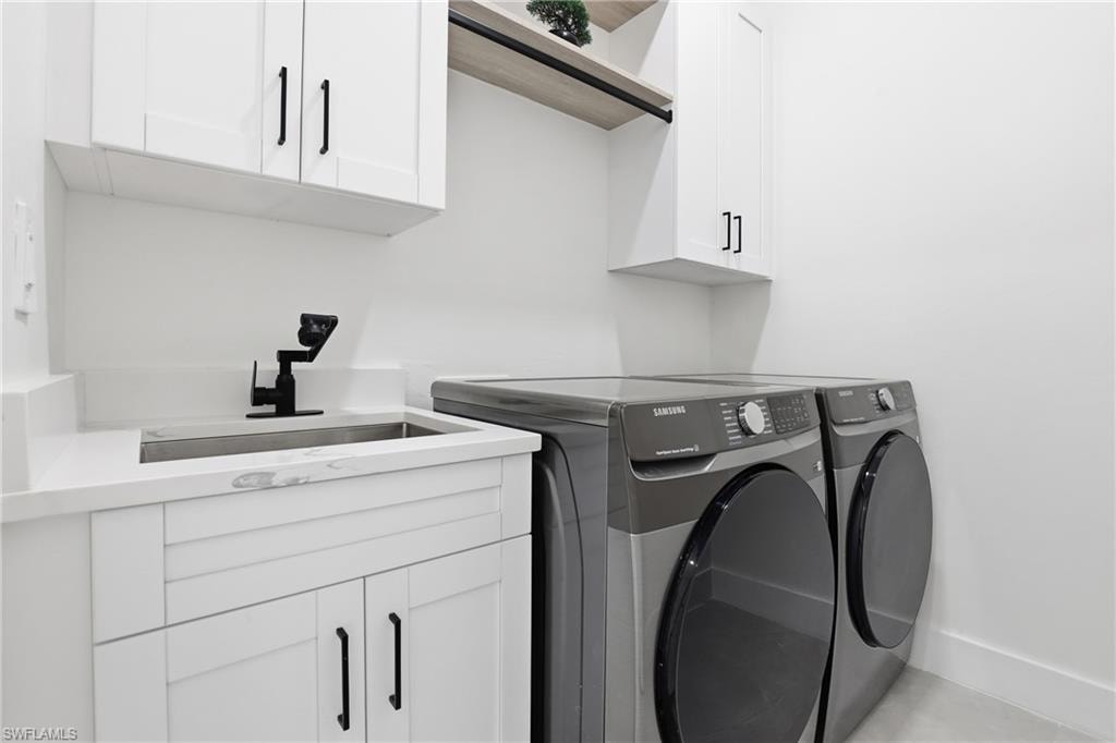 Washroom with washing machine and clothes dryer and cabinet space