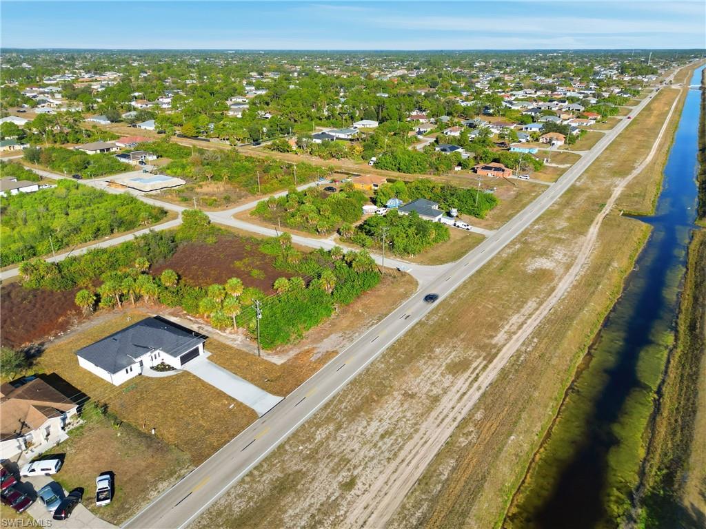 Aerial view of property and surrounding area with nearby suburban area