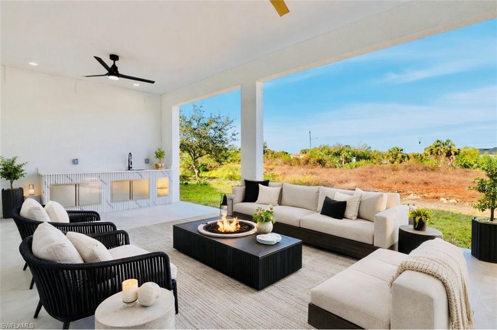 View of patio / terrace with ceiling fan and an outdoor living space with a fire pit. Digitally Staged
