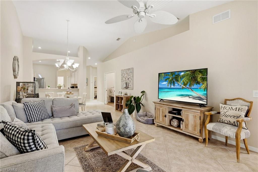 Living area featuring a chandelier, a ceiling fan, light tile patterned floors, recessed lighting, and high vaulted ceiling