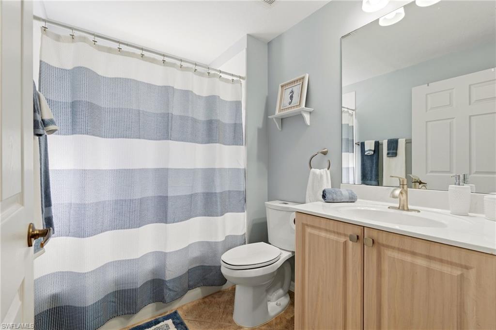 Bathroom featuring a shower with curtain, vanity, and light tile patterned floors