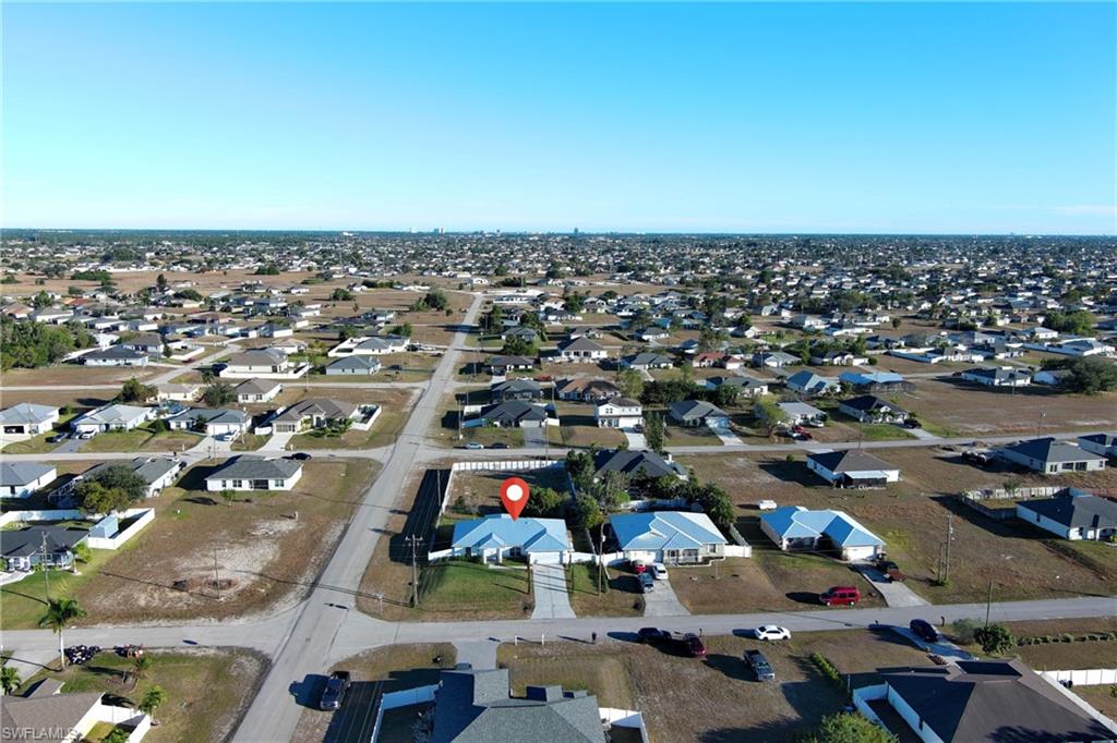 Aerial view of property and surrounding area with nearby suburban area