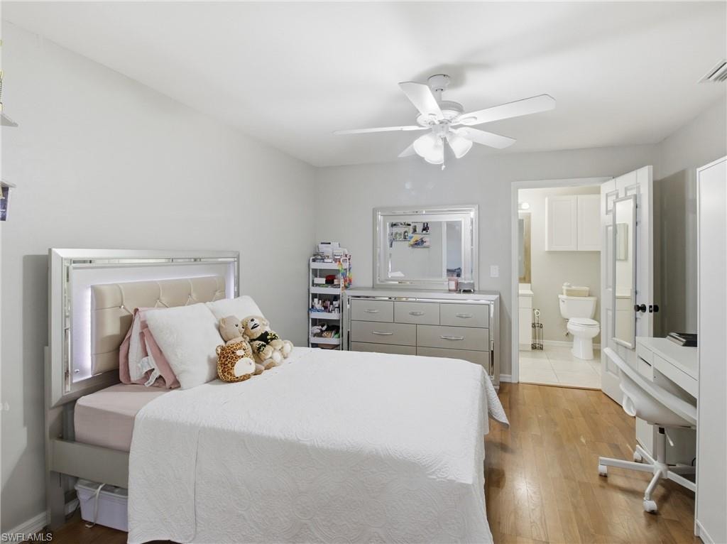 DEN turned into Bedroom featuring light wood-style flooring, ceiling fan, and connected bathroom