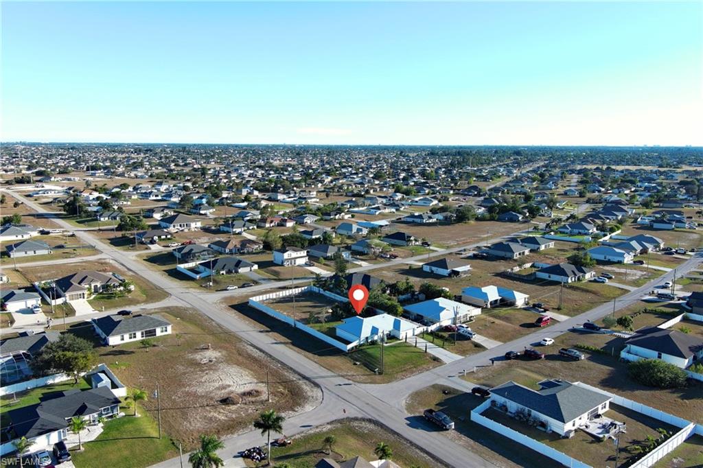 Aerial view of property and surrounding area with nearby suburban area