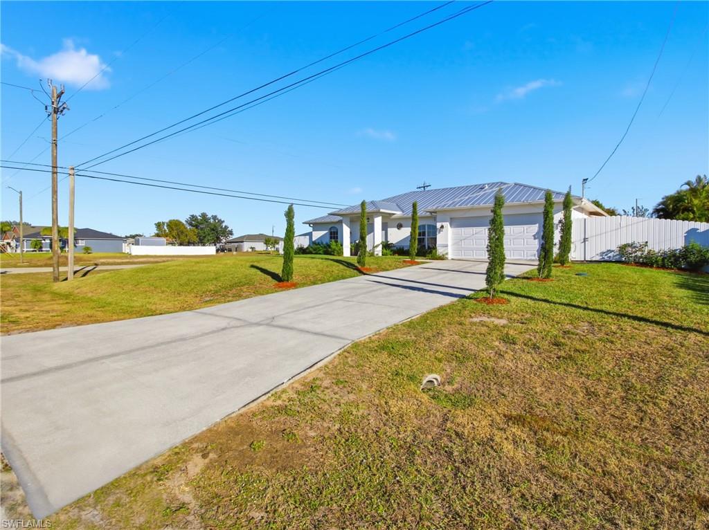 View of yard featuring driveway, a residential view, and a garage