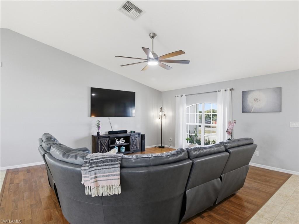 Living room featuring wood finished floors, lofted ceiling, and ceiling fan