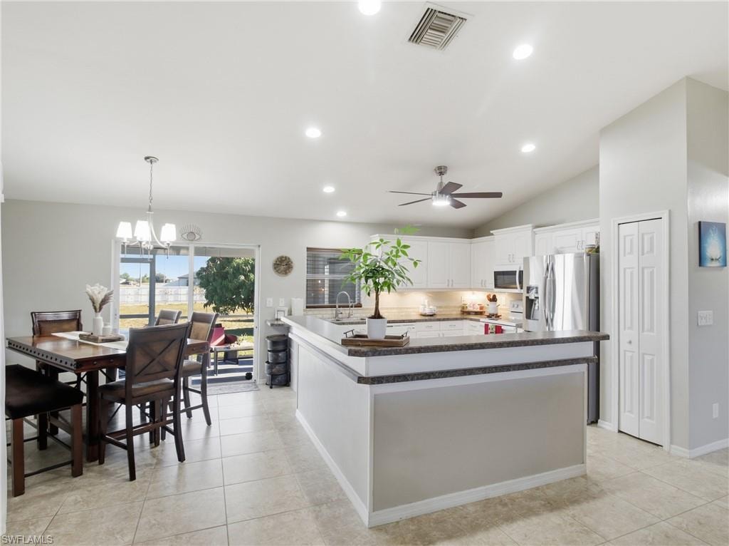 Kitchen featuring pendant lighting, white cabinetry, a chandelier, recessed lighting, and tasteful backsplash