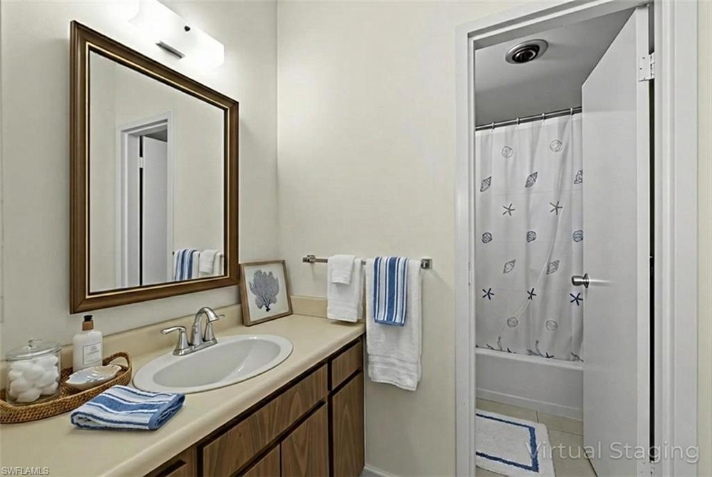 Full bathroom with vanity, shower / bath combination with curtain, and light tile patterned floors