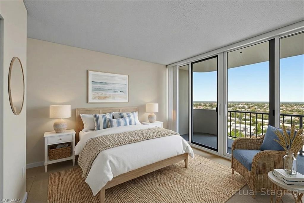 Bedroom featuring access to outside, a textured ceiling, and a wall of windows
