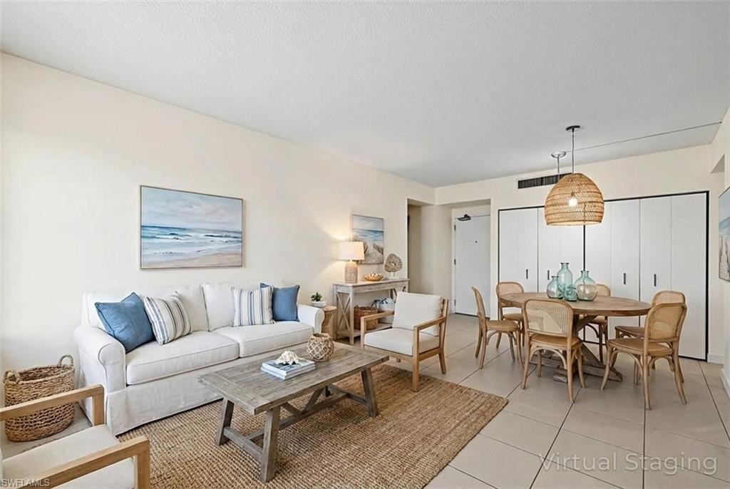Living area featuring light tile patterned floors and a textured ceiling