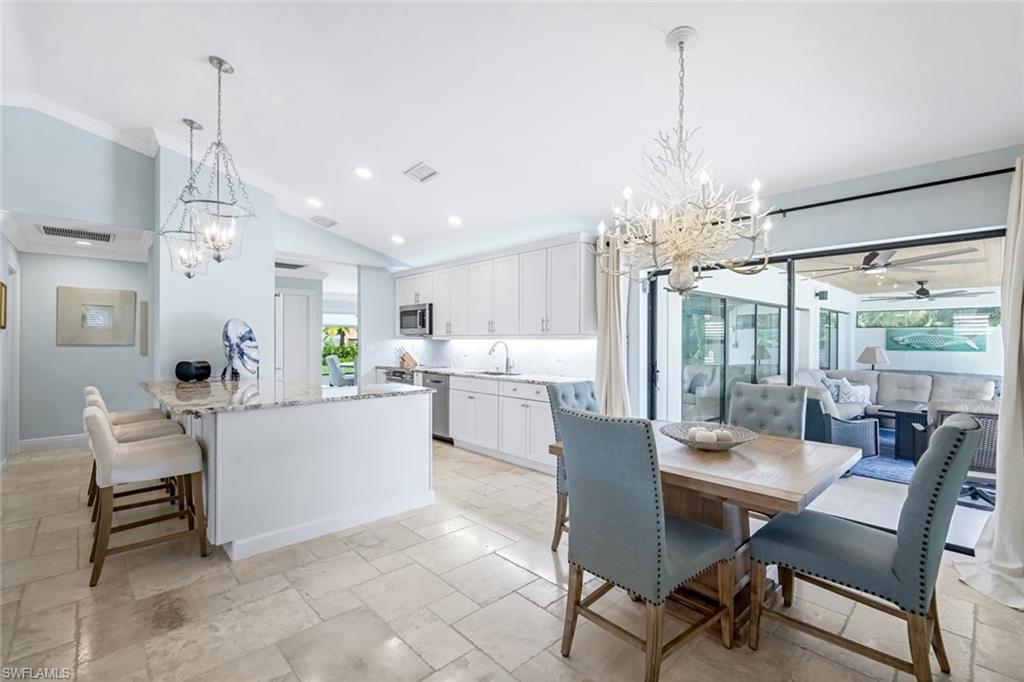 Kitchen with 42" wood white cabinets, plenty of natural light, and breakfast bar. Extra storage underneath breakfast bar.