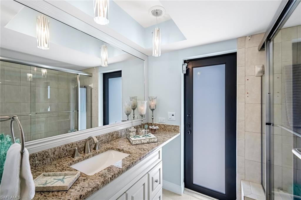 Guest bathroom with access to lanai features a shower/tub combo. Single vanity with a dressing area.