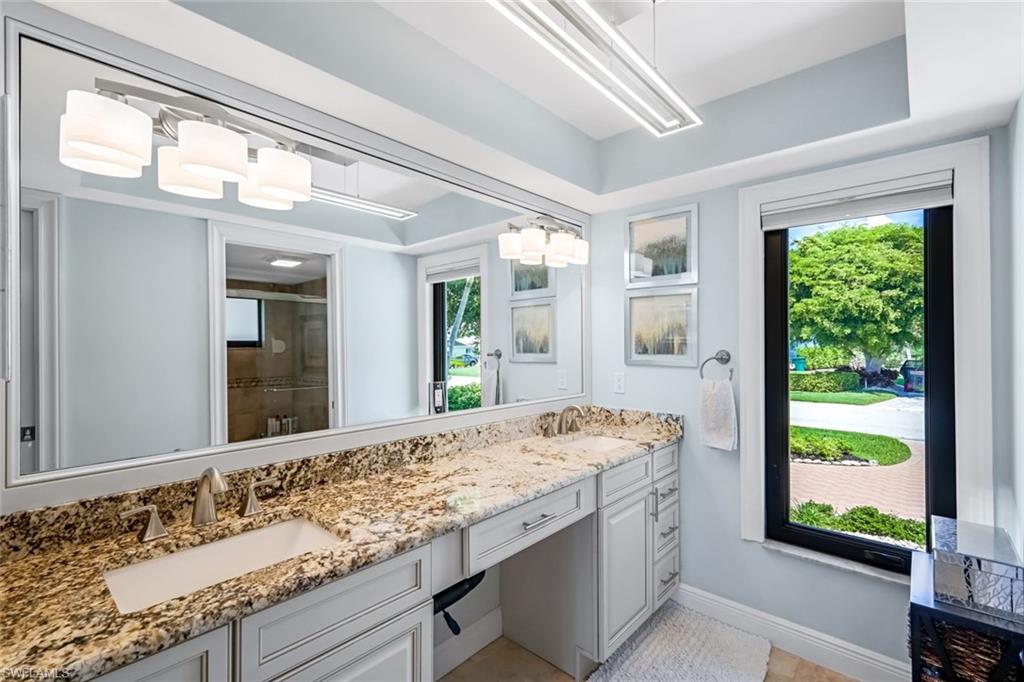 Primary bathroom with spa-inspired finishes offering dual vanities with Level 3 granite. Tray ceiling, contemporary lighting