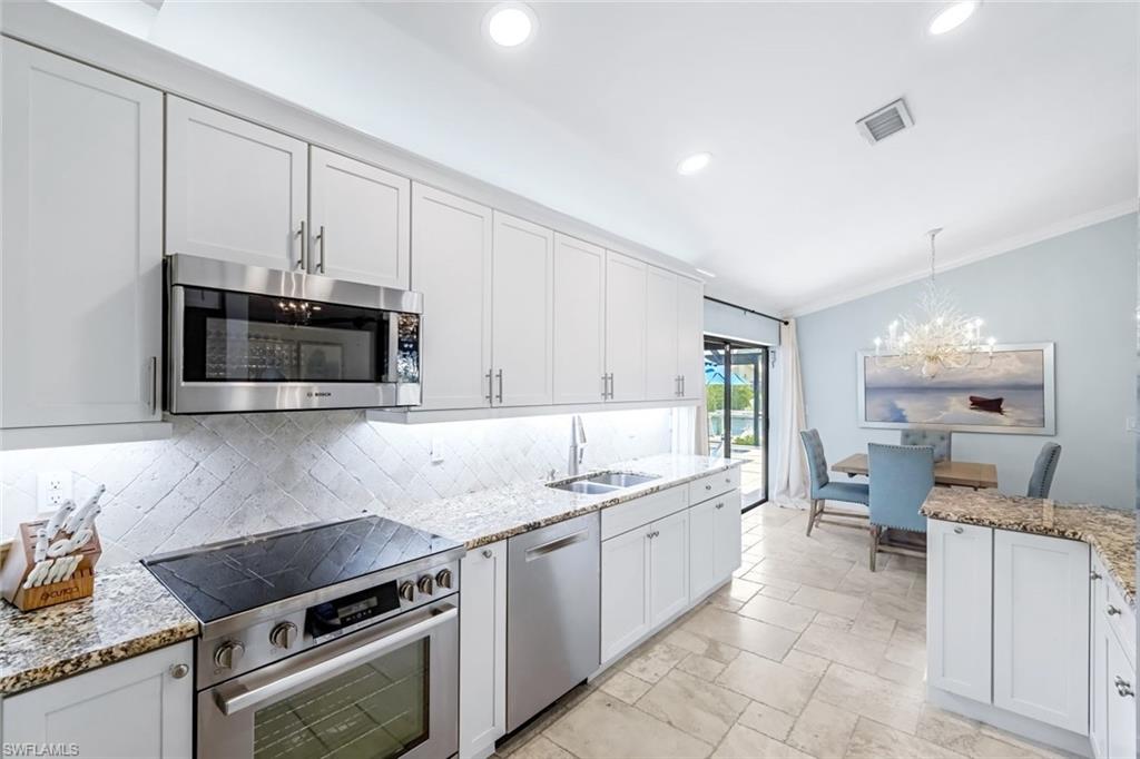 Bright & open kitchen with Bosch appliance package and level 3 granite countertops. Receessed lighting and under cabinet lighting. There is multicolored above cabinet lighting as well.