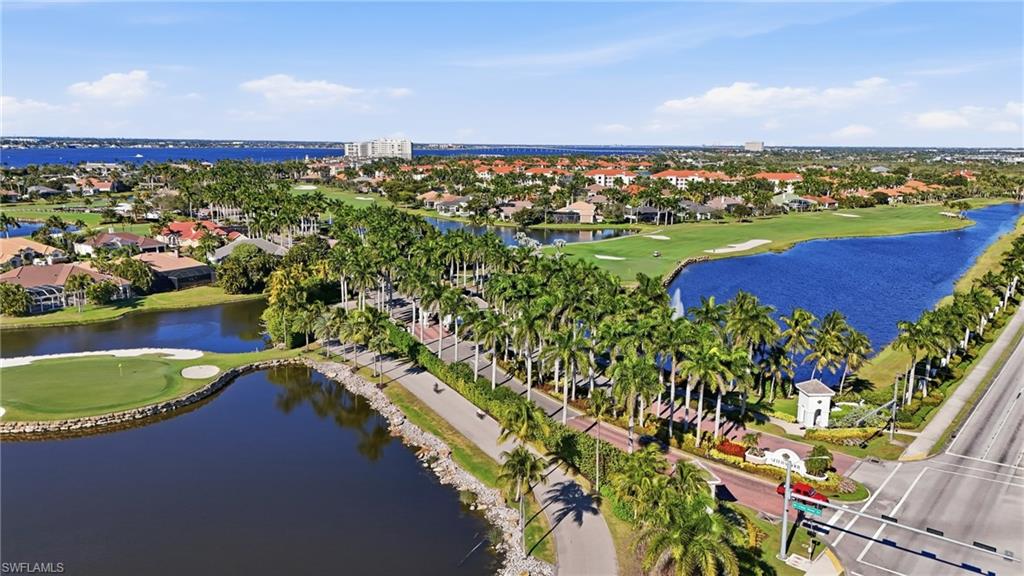 Aerial view of residential area featuring a golf club and a nearby body of water