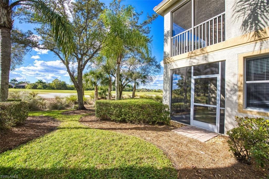 View of green lawn with a sunroom and a balcony