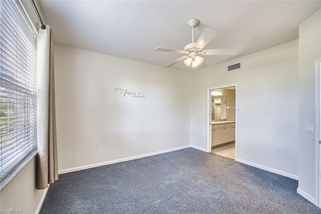 Carpeted spare room with baseboards and ceiling fan