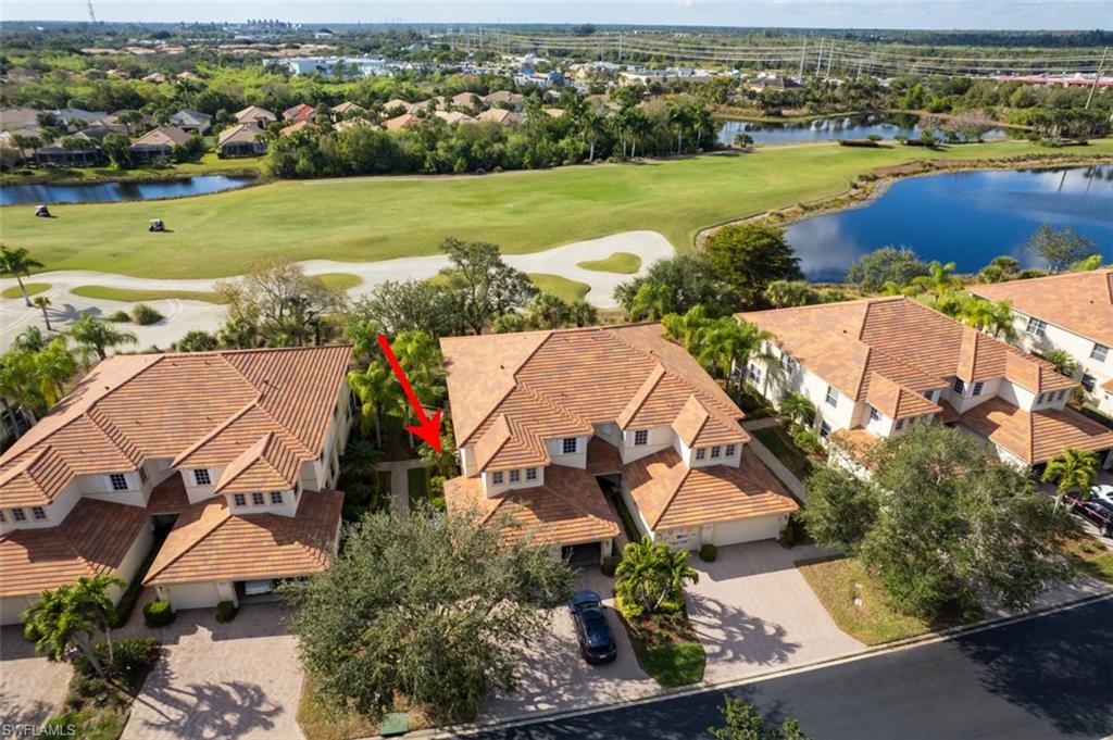Aerial view of residential area featuring a large body of water and a golf course