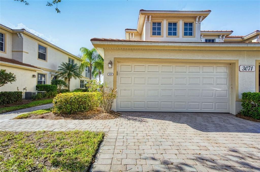 View of front of house with stucco siding, decorative driveway, and a tiled roof