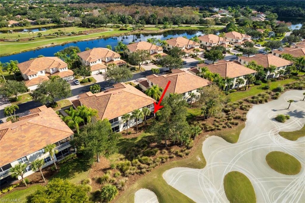 Aerial perspective of suburban area featuring a nearby body of water and a golf course