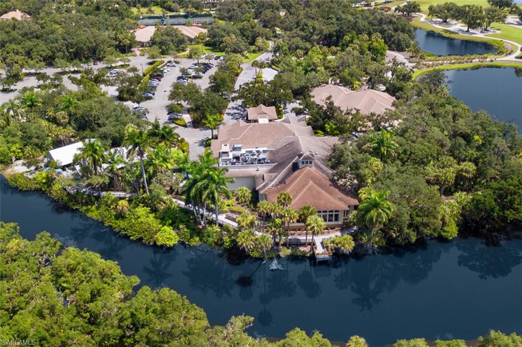 Aerial view of property's location featuring a large body of water and a tree filled landscape