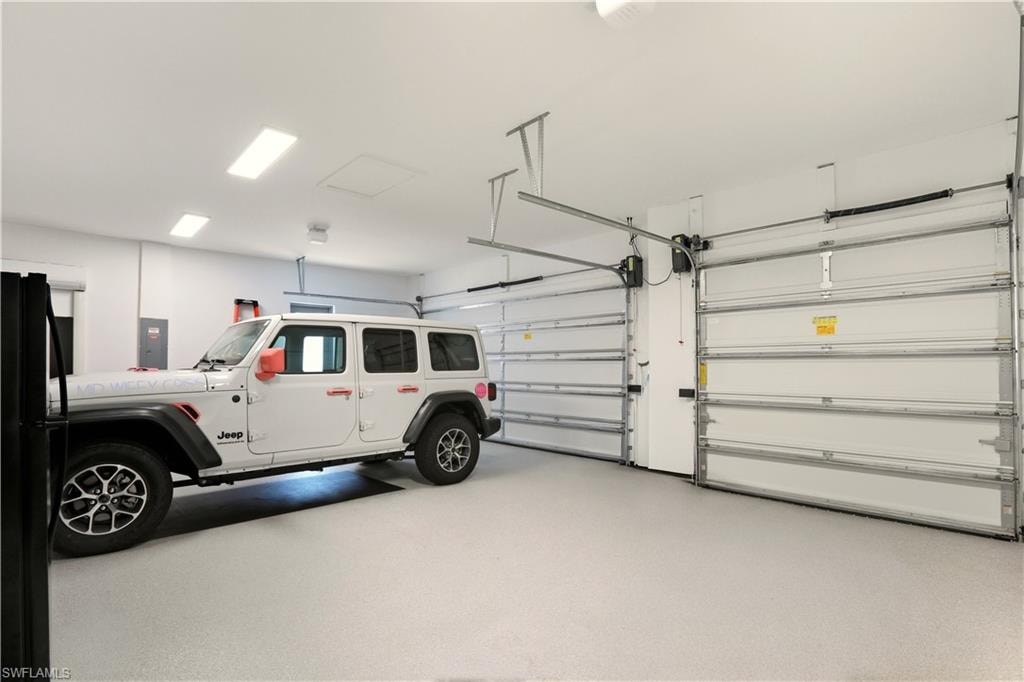 Garage featuring freestanding refrigerator and electric panel