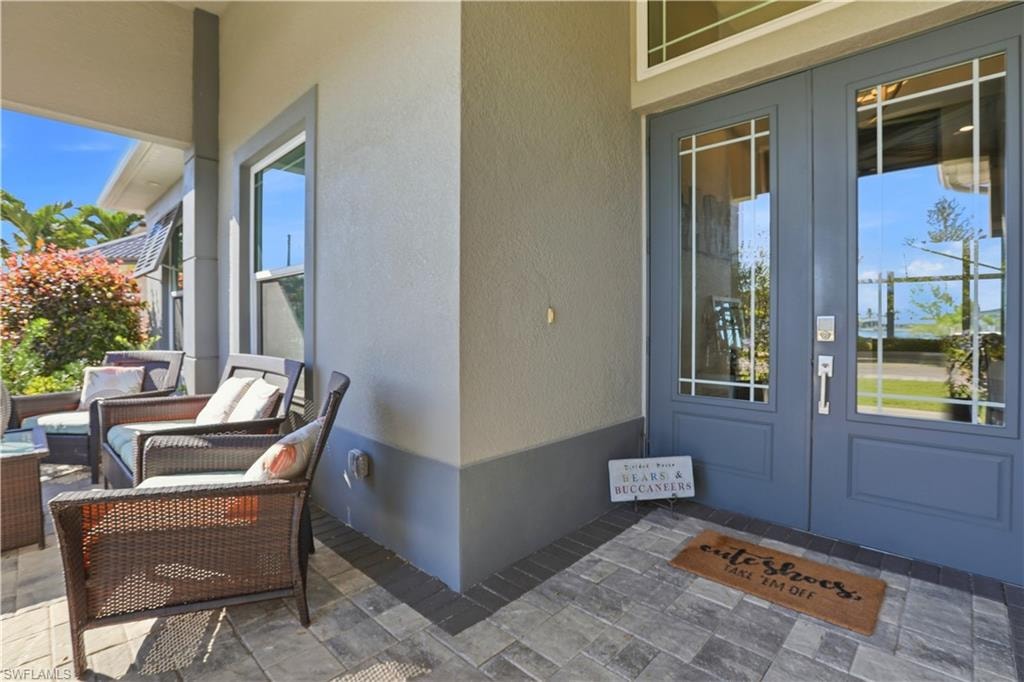 Doorway to property with solid french doors, stucco siding, and a comfortable outdoor living space