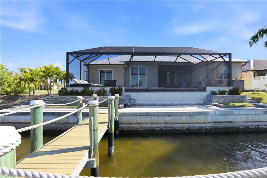 Rear view of house featuring concrete seawall and concrete decking.