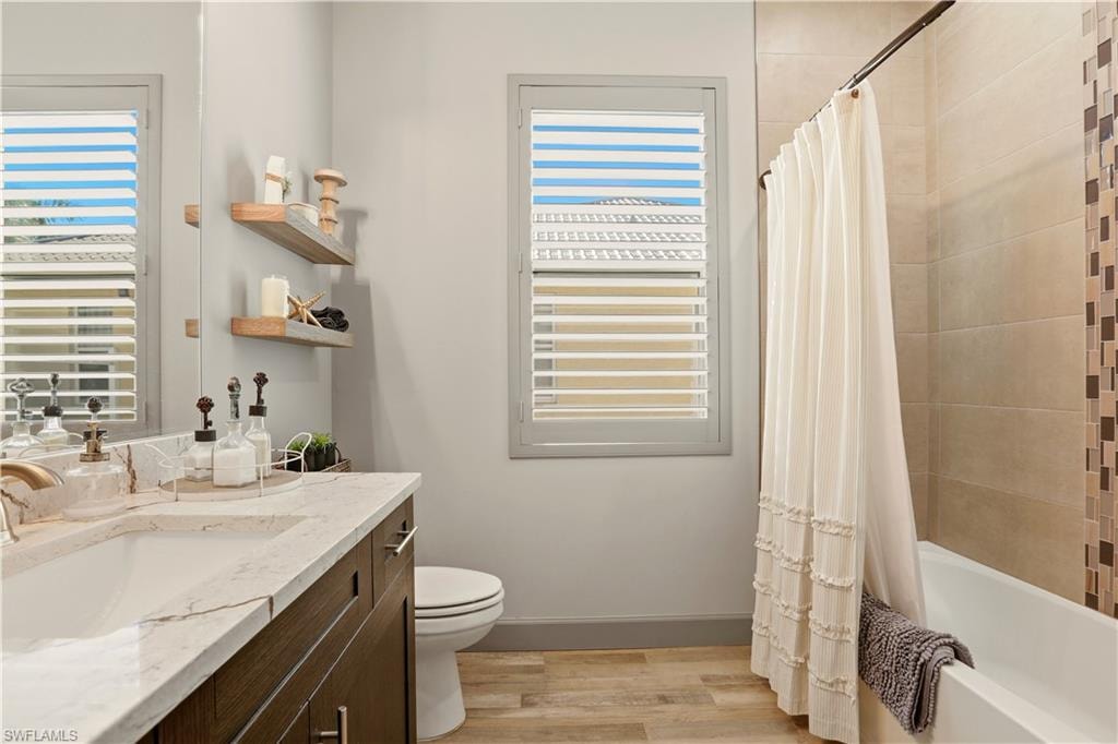 2nd Bathroom featuring shower / bath combination with curtain, vanity, and light wood-style flooring