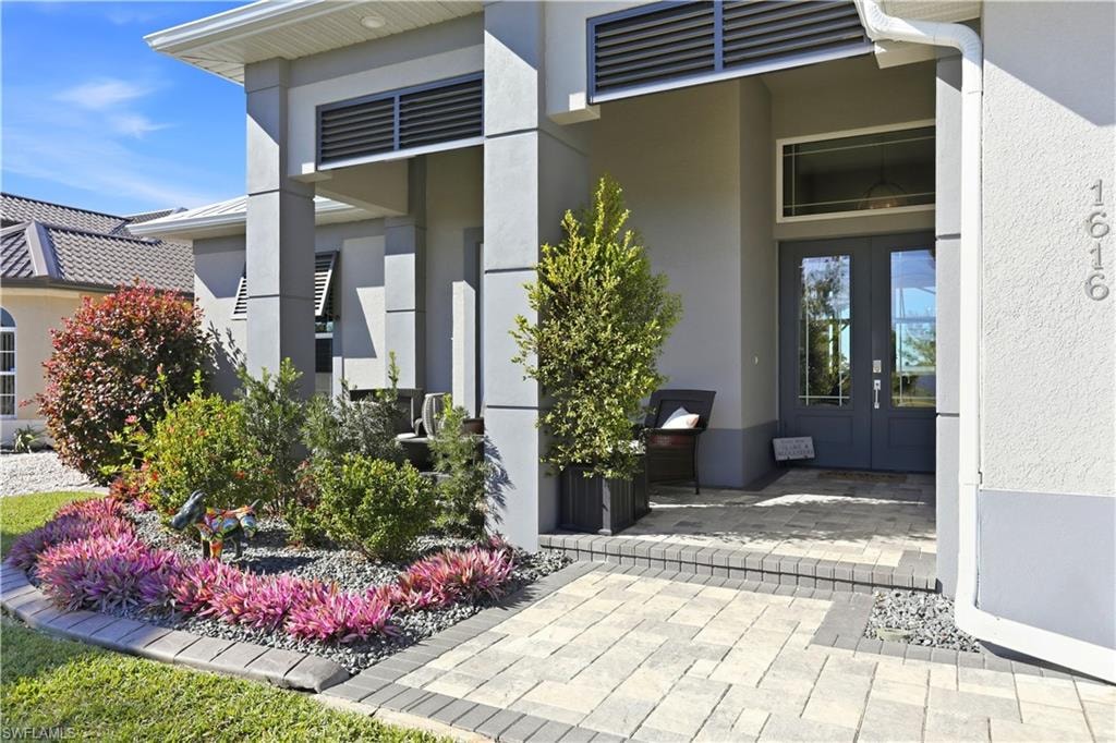 Entrance to property featuring french doors and stucco siding