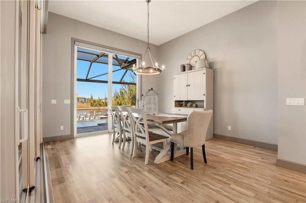 Dining area with light wood-type flooring and a chandelier