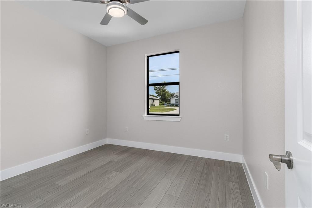 Empty room with light wood finished floors and a ceiling fan