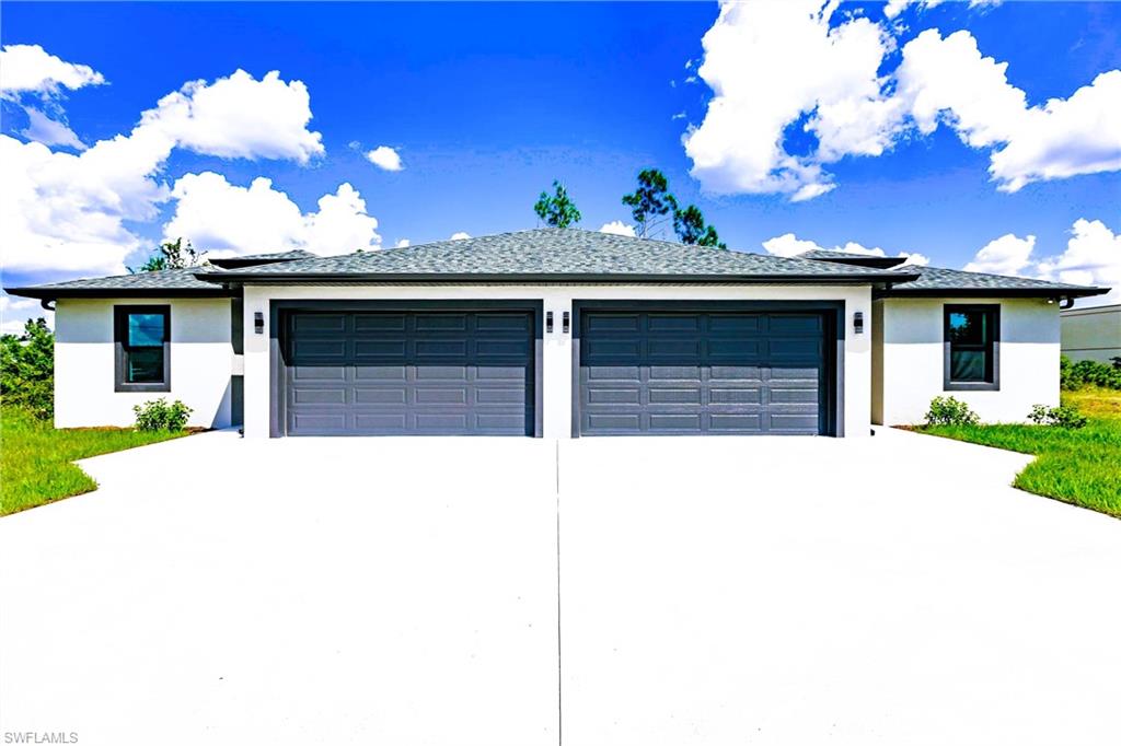 View of front of home featuring stucco siding, a garage, driveway, and a shingled roof
