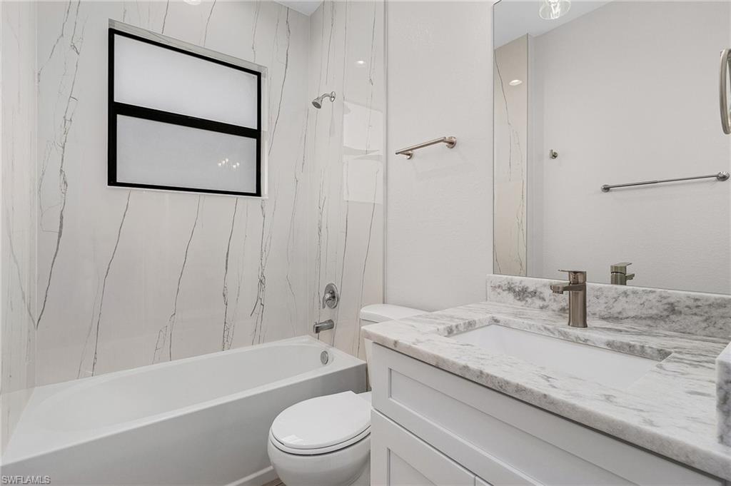 Bathroom featuring vanity and washtub / shower combination