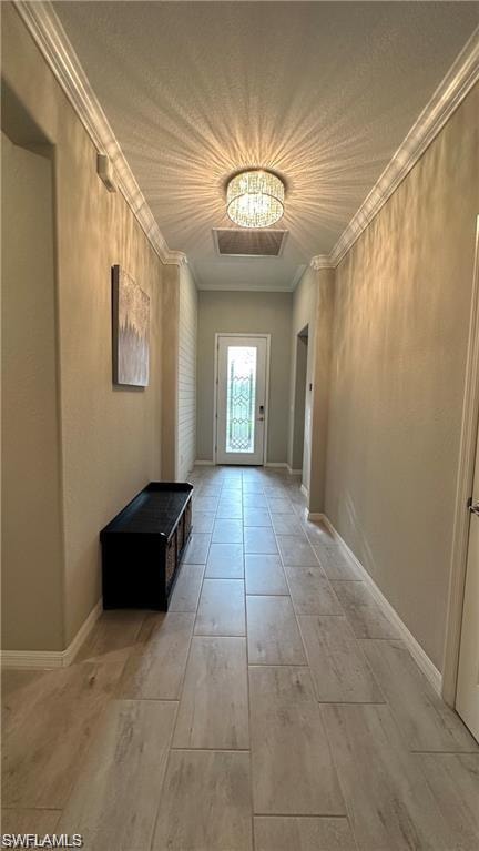 Doorway with light wood finished floors, ornamental molding, and baseboards