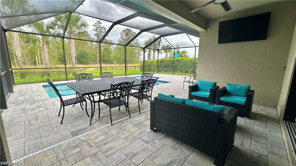 View of patio / terrace featuring ceiling fan, a lanai, and an outdoor living space