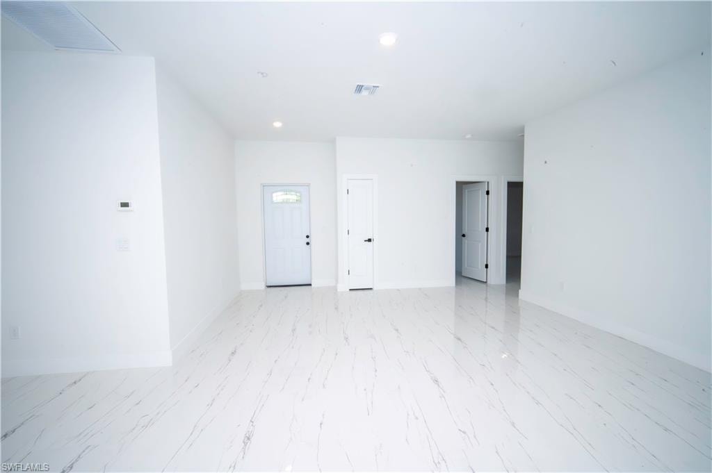 Empty room with baseboards and recessed lighting