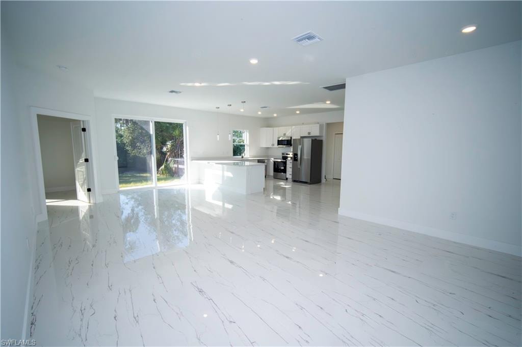 Unfurnished living room with recessed lighting and light marble finish floors