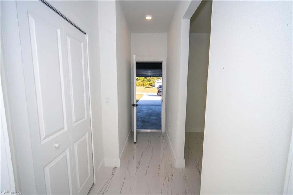 Hall featuring recessed lighting and light marble finish floors