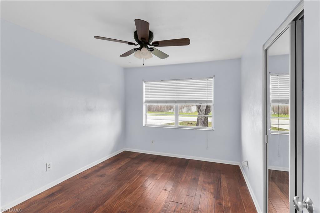 Spare room with dark wood finished floors and a ceiling fan